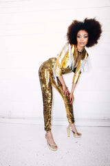 Woman with afro wearing gold sequin pants as part of a disco costume