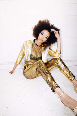 Woman wearing gold sequin pants as part of a festival outfit