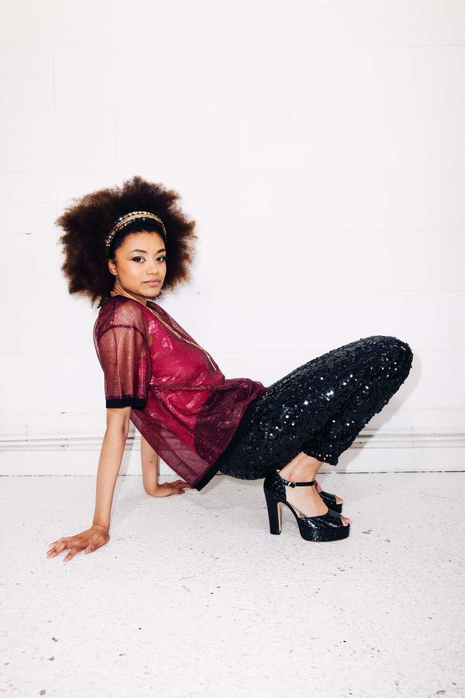 Woman wearing black sequin pants and red sheer t-shirt as festival outfit